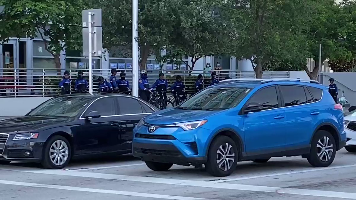 Police officers are nearby in Downtown Miami close to the crowd.
