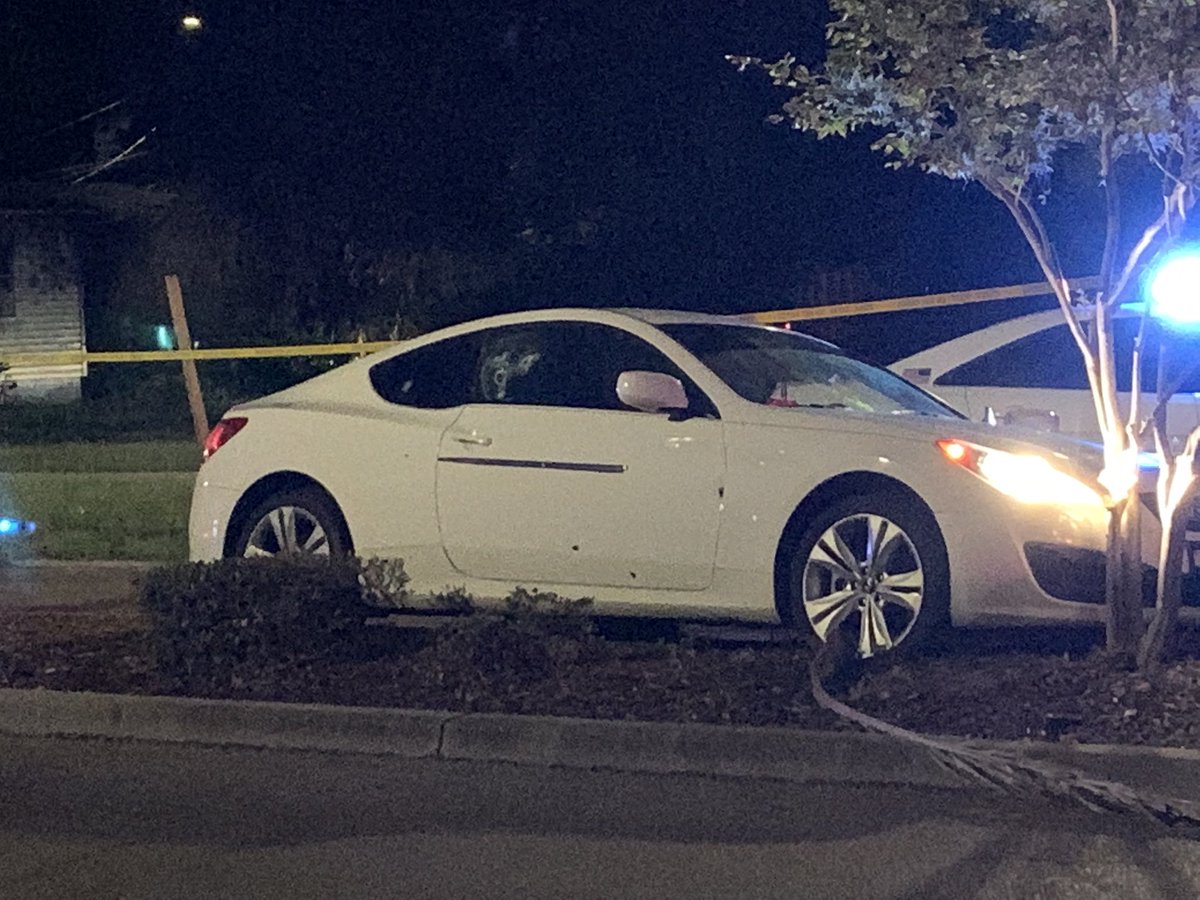 This white Hyundai is riddled with bullet holes.  The engine is still running.