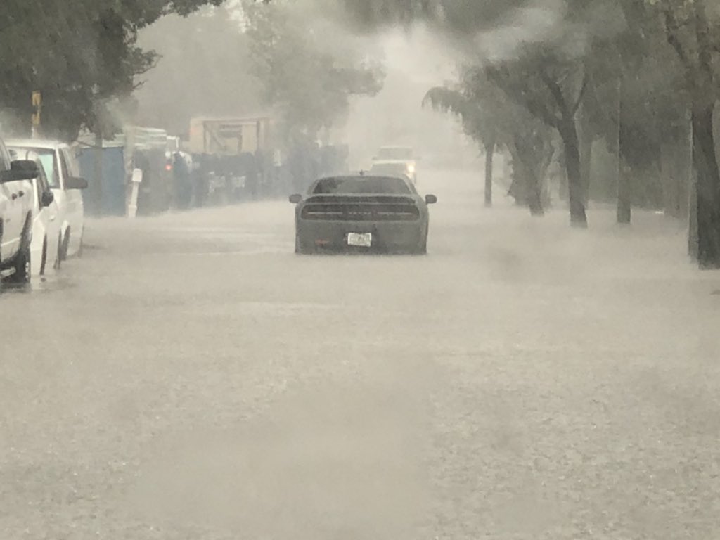 Heavy rain in West Palm Beach east of US1 causing street flooding. I'm not sure but it looks like this car may be stuck in the middle of the road from the high water