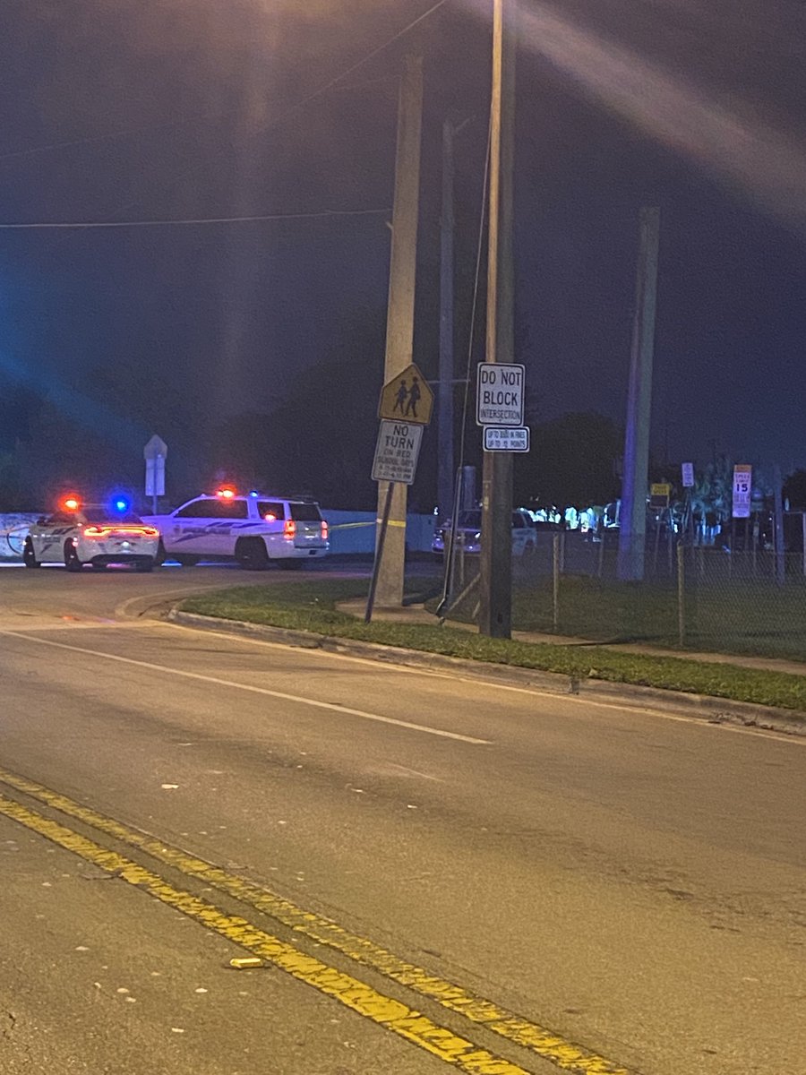 Officers shouting with megaphone behind police tape in Miami Springs  