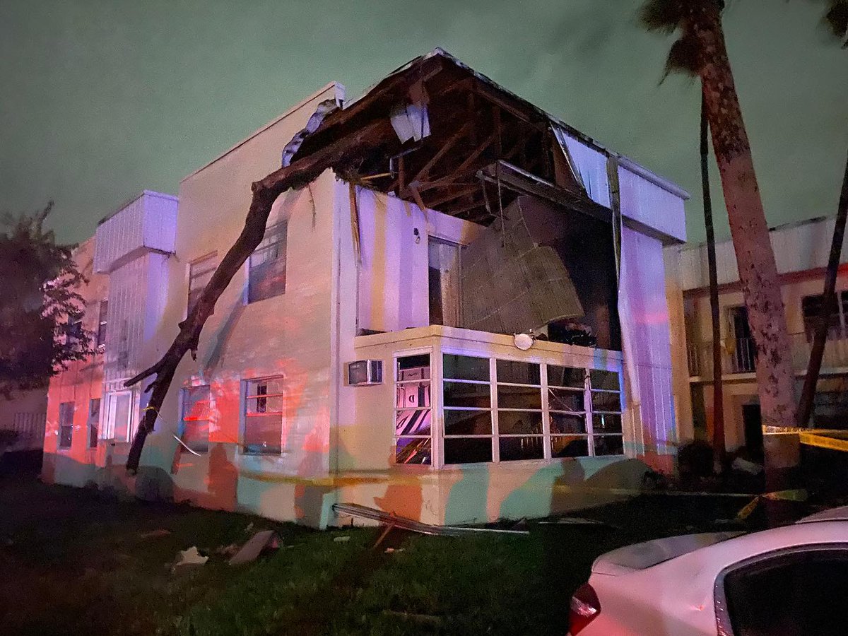 A possible tornado injured two people, overturned cars and ripped the roof off an apartment complex.   A tornado warning remains for much of South Florida