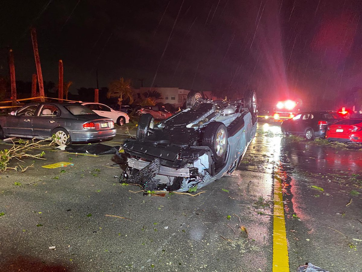 A possible tornado injured two people, overturned cars and ripped the roof off an apartment complex.   A tornado warning remains for much of South Florida