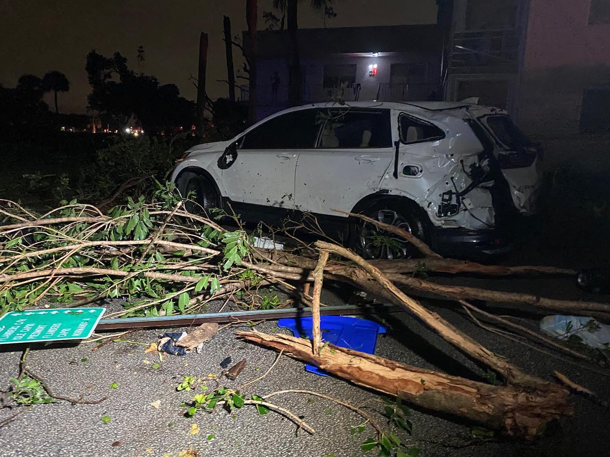 A possible tornado injured two people, overturned cars and ripped the roof off an apartment complex.   A tornado warning remains for much of South Florida