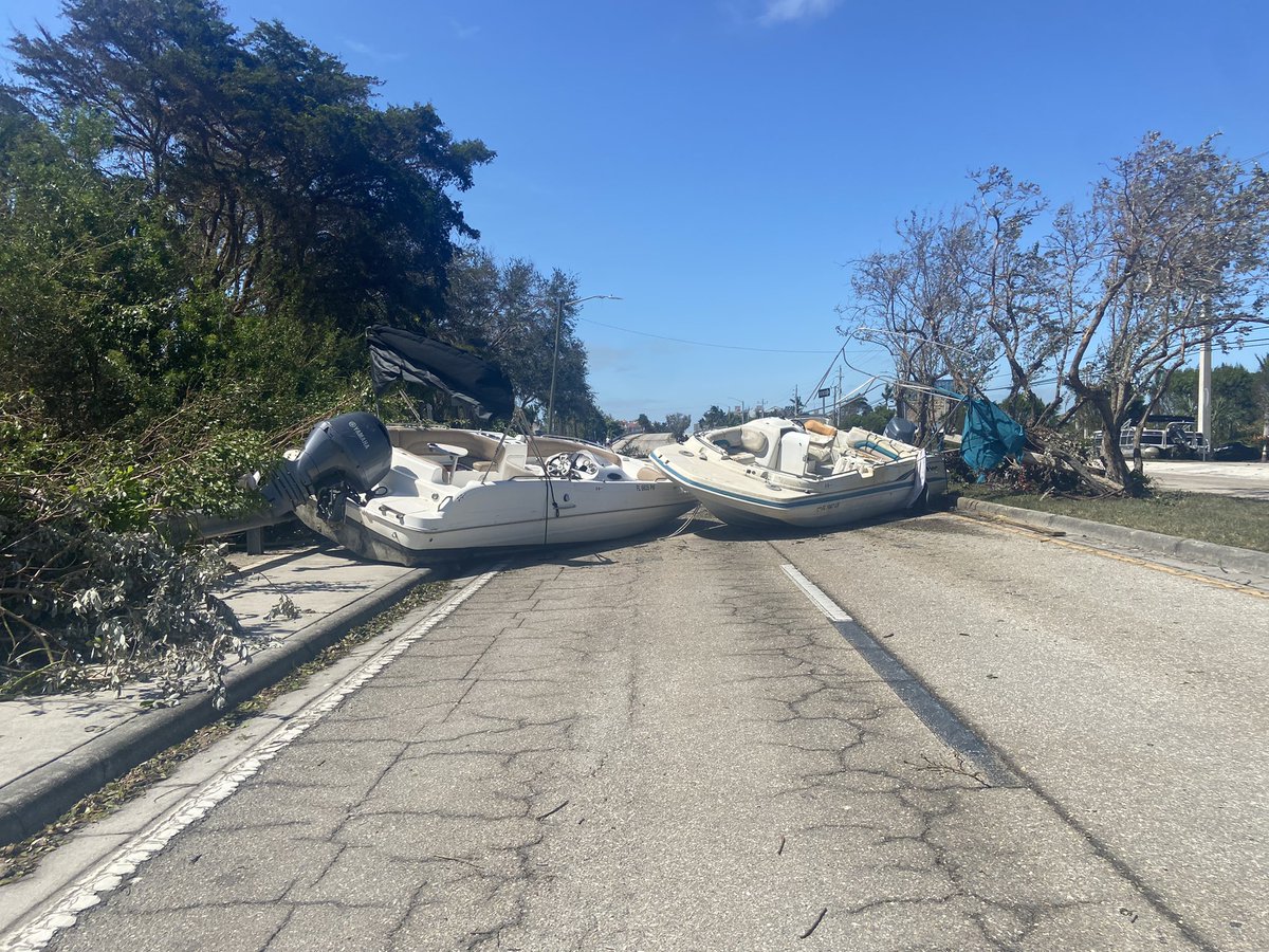 A Rolls Royce somehow ended up behind this guardrail and wedged in this tree. Also, these two boats are blocking off a section of Bonita Beach Road. There are three other boats about a quarter of a mile up the road sitting along the sidewalk