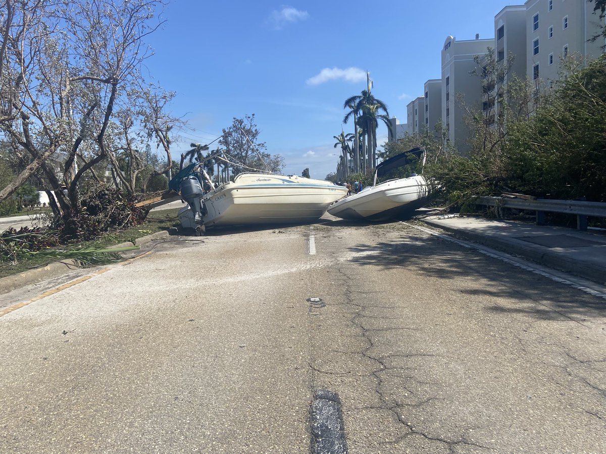 A Rolls Royce somehow ended up behind this guardrail and wedged in this tree. Also, these two boats are blocking off a section of Bonita Beach Road. There are three other boats about a quarter of a mile up the road sitting along the sidewalk